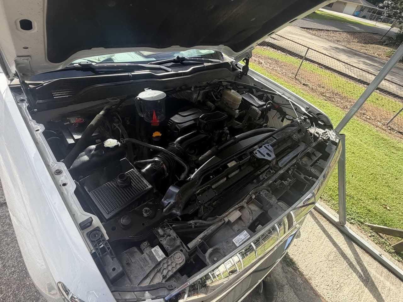 The same pickup engine bay after service, cleaned up and noticeably darker